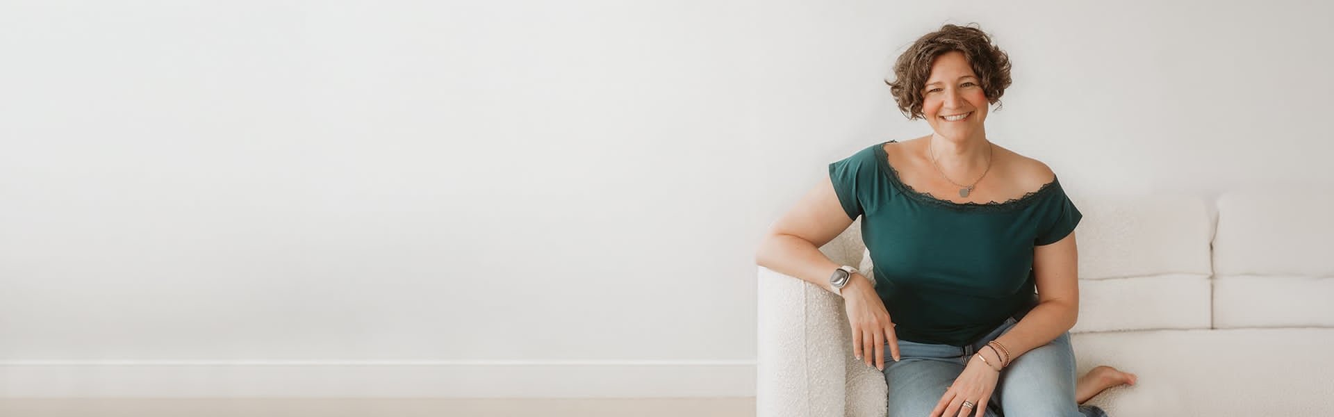Mandy Kuelz smiling, seated on a couch